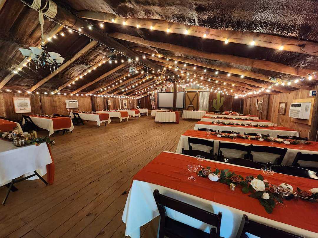 Rustic event barn set with long reception tables and string lights