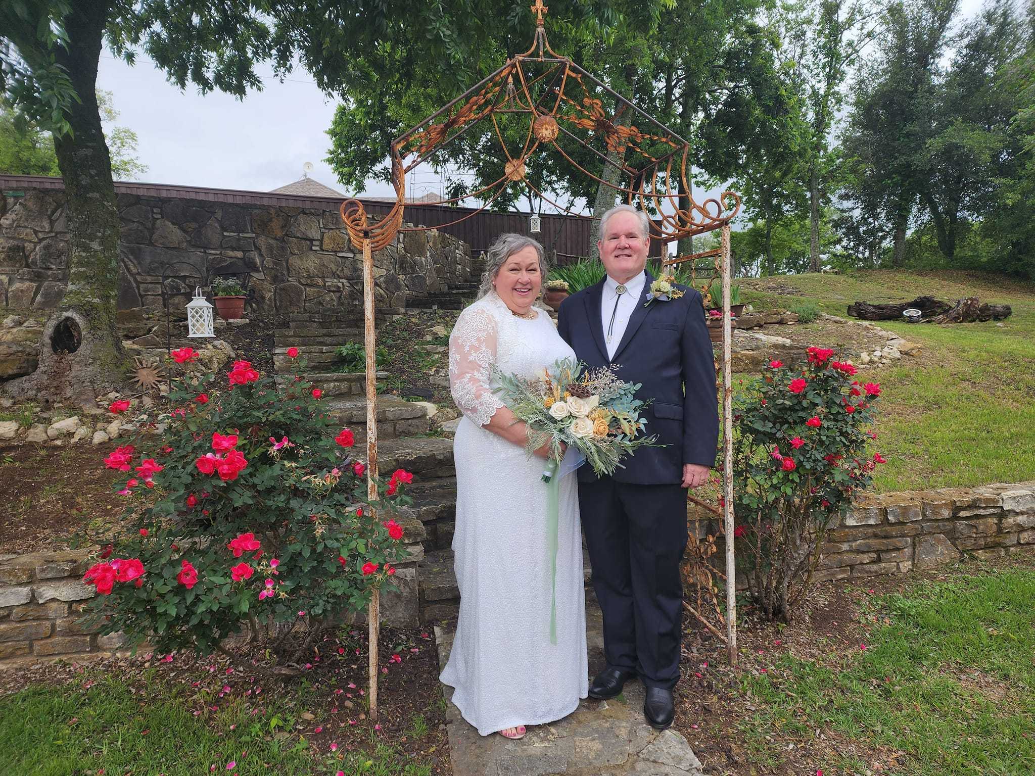 Wedding couple posing near the garden ceremony area